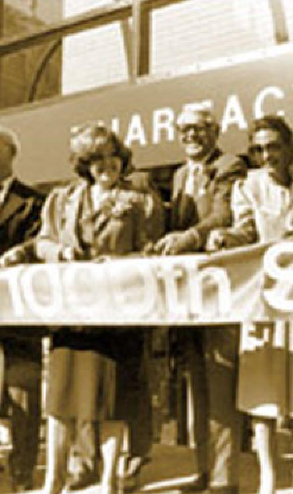 Crowd holds up a large ribbon for cutting at the opening of the 1,000th Walgreens store