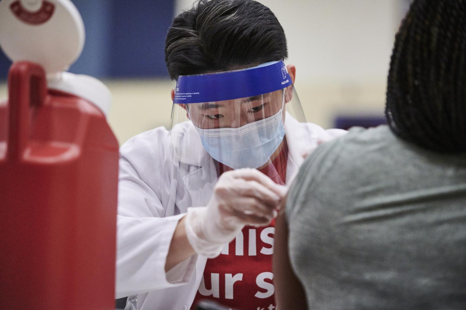 Male pharmacist with face shield applied bandage