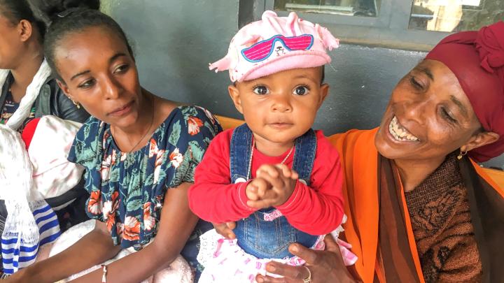 Mother and baby sitting outside clinic in Ethiopia 