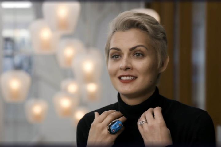 Head and shoulders of a smiling woman in a room