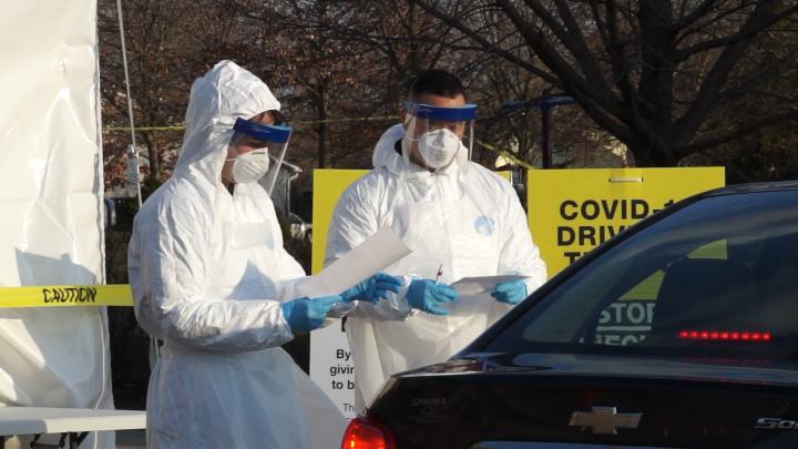 Workers at a drive thru testing facility