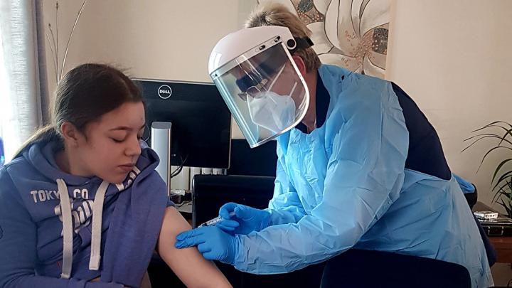 Alcura nurse Kathie Roberts, wearing her full personal protective equipment, gives an injection to patient Alyssa Jacobs during a recent home visit in the UK. As part of its wide-ranging work with health care companies and professionals in seven European countries, Alcura provides home medical services.