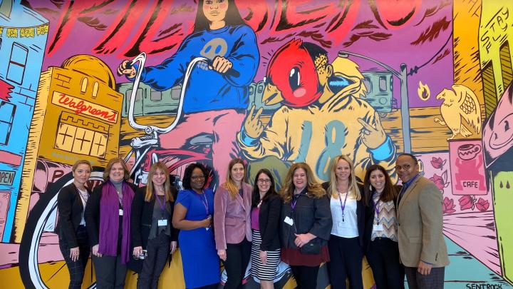 Women standing in front of mural background